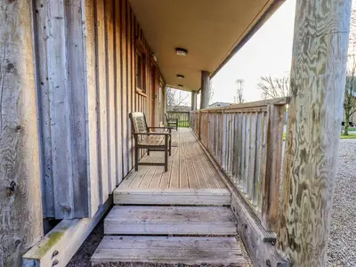 a rocking chair sitting on a porch of a house at Larch Lodge in Penrith
