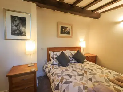 a bedroom with a bed with pillows on it at Barn Owl Cottage in Penrith