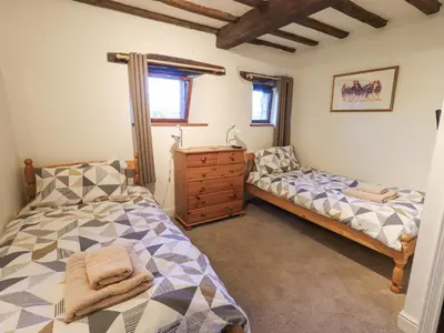 a bedroom with a bed and a dresser in it at Barn Owl Cottage in Penrith