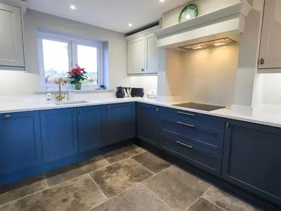 a kitchen with blue cabinets and a sink at The Elterwater Barn in Workington