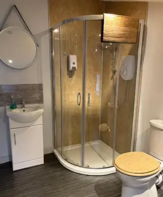 a bathroom with a shower with a toilet and a sink at Unique, Large 2 bedroom Flat in Carlisle