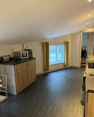 an empty room with a kitchen with a microwave at Unique, Large 2 bedroom Flat in Carlisle