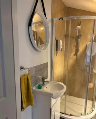 a bathroom with a shower and a sink and a mirror at Unique, Large 2 bedroom Flat in Carlisle