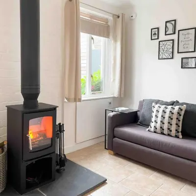 a living room with a fireplace and a couch at The Retreat, self-contained cosy Anex, M6 A75 Gretna Green in Rigg