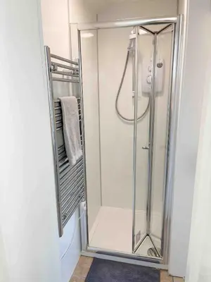 a shower with a glass door in a bathroom at The Retreat, self-contained cosy Anex, M6 A75 Gretna Green in Rigg