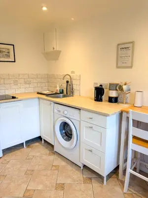 a kitchen with a washing machine in a counter at The Retreat, self-contained cosy Anex, M6 A75 Gretna Green in Rigg
