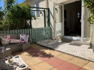 a patio with a couch in front of a house at The Bunker, Golf Cottage in Prestwick