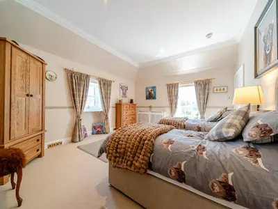 a bedroom with a bed and a large window at Mossknowe Escape in Annan