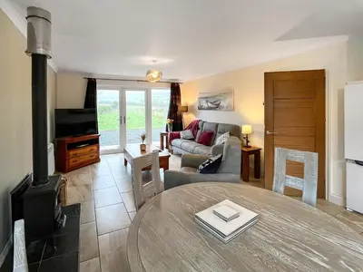 a living room with a couch and a stove at Flo's Cottage in Eldrig Village