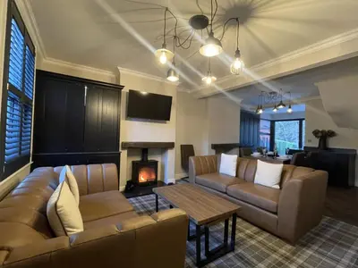 a living room with two couches and a fireplace at Greta House in Keswick