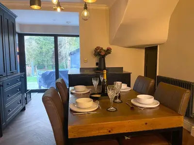 a dining room with a wooden table and chairs at Greta House in Keswick