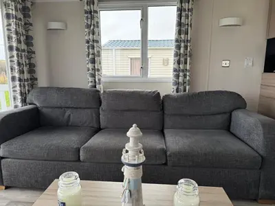 a living room with a couch and a table at The Retreat - Turnberry Holiday Park Amazing Sea View in Girvan