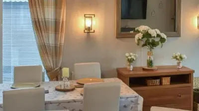a dining room with a table with chairs and flowers on it at Woodland Lodge in Plumbland