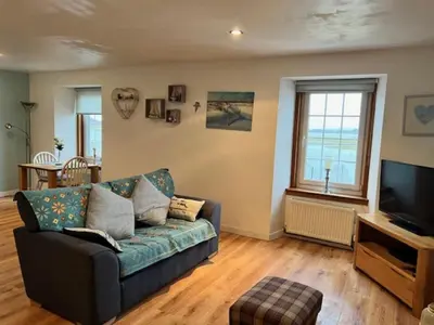 a living room with a couch and a television at Harbour View Irvine in Irvine