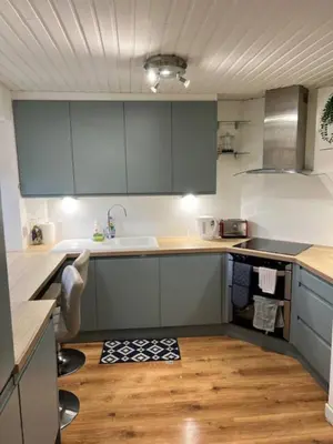 a kitchen with blue cabinets and a wooden floor at Harbour View Irvine in Irvine