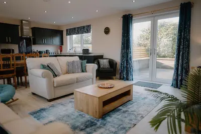 a living room with a couch and a coffee table at Cosy wee cottage -modern, open plan, parking, EV in Glencaple