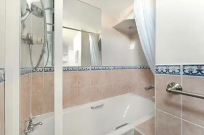 a bathroom with a bath tub and a shower at Rowan Studio Cottage in Grasmere