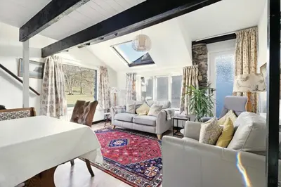 a living room with a white table and chairs at Rowan Studio Cottage in Grasmere