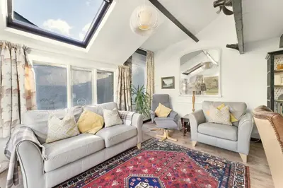 a living room with a couch and chairs and a window at Rowan Studio Cottage in Grasmere