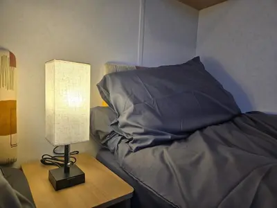 a bedroom with a bed and a lamp on a table at Elf Wood Lodge - Swimming Spa, Sky Sports, Tennis, Hadrian's Wall listing in Port Carlisle