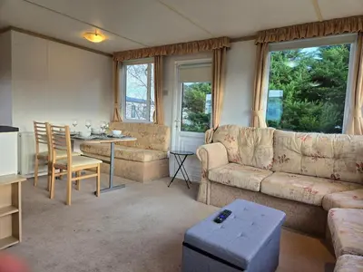 a living room with a couch and a table at Elf Wood Lodge - Swimming Spa, Sky Sports, Tennis, Hadrian's Wall listing in Port Carlisle