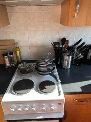 a white stove top oven with pots and pans on it at A Cozy One Bedroom Flat for Two Guests in Carlisle