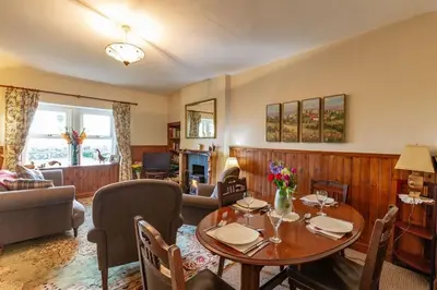 a living room with a table and a couch at No1 Chapelton Cottage in Kirkcudbright
