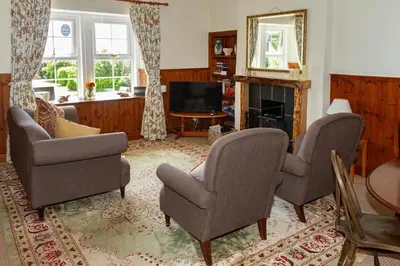 a living room with two chairs and a television at No1 Chapelton Cottage in Kirkcudbright