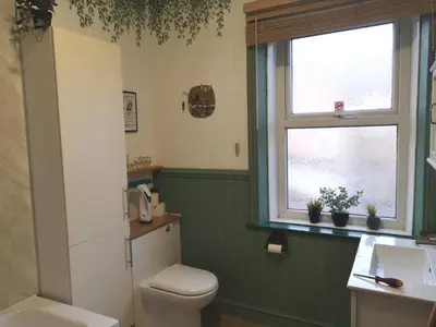 a bathroom with a toilet and a sink and a window at Carlisle Homestay - Family Room in Carlisle