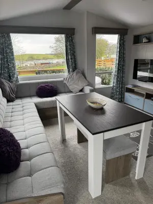a living room with a table and a couch at 131 Loch View Three Lochs Holiday Park in Newton Stewart