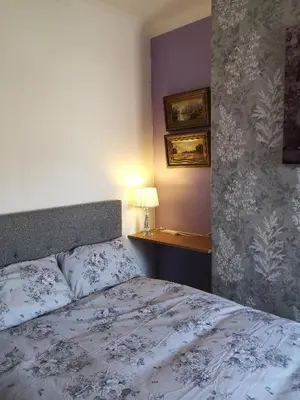 a bedroom with a bed and a table with a lamp at Carlisle Homestay - Double Room in Carlisle