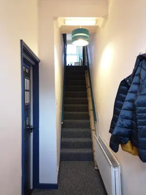 a stairway leading up to a hallway with a blue door at Carlisle Homestay - Double Room in Carlisle