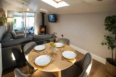 a dining room with a wooden table and chairs at Hidden Hive in Gretna