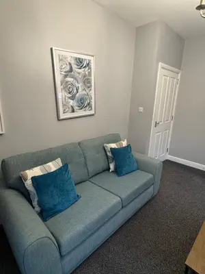a blue couch in a living room with blue pillows at Omega Apartment - 3 Bedrooms - Sleeps 5 in Whitehaven