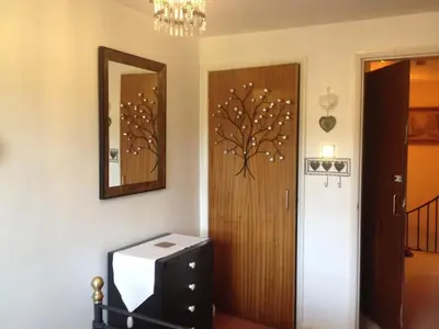 a room with a door and a dresser and a mirror at Cosy home in centre of Lake District National Park in Chapel Stile