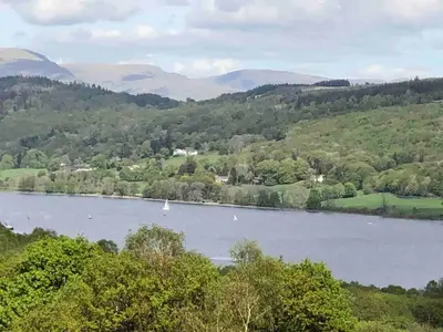 a view of a lake with a boat in it at Cosy home in centre of Lake District National Park in Chapel Stile