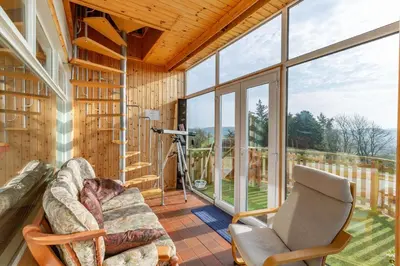 a living room with a couch and a window at Dunrod - Overlooking the bay in Kirkcudbright