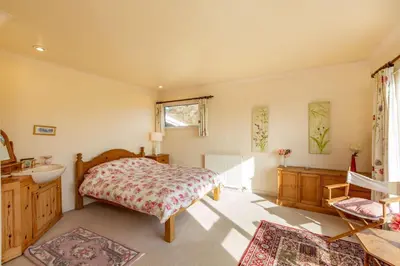 a bedroom with a bed and a sink at Dunrod - Overlooking the bay in Kirkcudbright