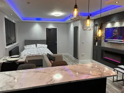 a bedroom with a bed and a living room with a table at Modern Junior Suite, Seascale, Cumbria in Seascale