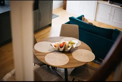 a table with a bowl of fruit on it in a living room at Mount Auldyn House - The Cottage in Ramsey