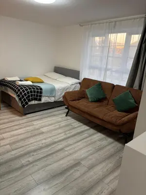 a living room with a couch and a bed at private Studio with its own kitchen and bathroom in Moffat