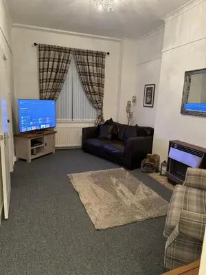 a living room with a couch and a flat screen tv at Hillhead Apartment in Coylton