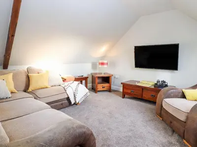 a living room with two couches and a flat screen tv at The Steading in Dumfries