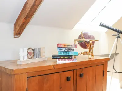 a pile of books sitting on top of a wooden cabinet at The Steading in Dumfries