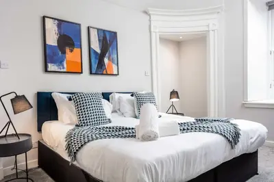 two beds in a white room with paintings on the wall at The Annick Suite No1 - Donnini Apartments in Irvine