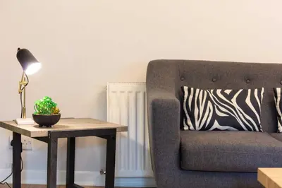 a living room with a chair and a table with a lamp at The Annick Suite No1 - Donnini Apartments in Irvine