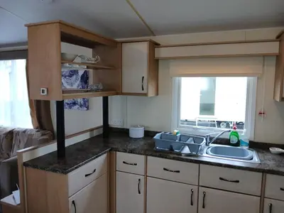 a small kitchen with a sink and a window at Harriet's Haven - Endless Pool, Tennis, Sky TV in Port Carlisle