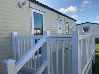 a white wooden deck with a white fence at Harriet's Haven - Endless Pool, Tennis, Sky TV in Port Carlisle