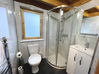 a bathroom with a shower and a toilet and a sink at Beautiful Countryside Lodge with Outstanding Views - Pass the Keys in Dumfries