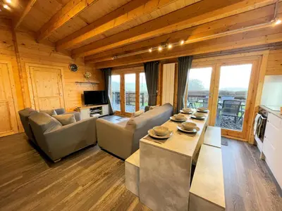 a living room with couches and a table in a house at Beautiful Countryside Lodge with Outstanding Views - Pass the Keys in Dumfries
